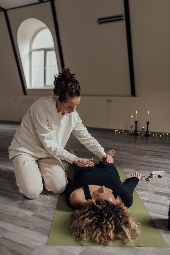 services-03 A woman is receiving Reiki therapy indoors, promoting relaxation and alternative healing.